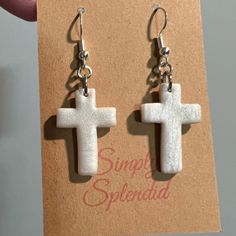 a pair of earrings with a cross on it