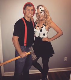 a man and woman dressed up in costumes posing for the camera with a baseball bat