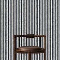 a wooden chair sitting in front of a striped wall