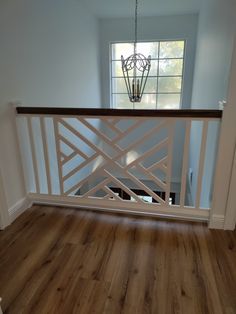 an empty room with hard wood floors and white railing