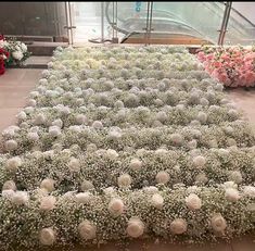 white flowers are arranged on the ground in front of an escalator