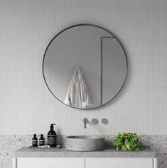 a bathroom with a round mirror above the sink