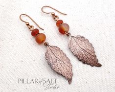 * Handmade in Minnesota by pressing a leaf vein design into copper. The copper has been given an antique finish for an earthy, boho vibe which really brings out the detailed textured design. Each pair will be slightly different and unique as each one is made individually. * The matte Carnelian gemstones are in varying shades of reds and oranges. * Ear wires are solid copper. * Total length with ear wires is 2-1/2 inches. They are 5/8" wide. * Theme/style: autumn, fall, boho, bohemian, earthy, rustic, nature, artisan. Bohemian Leaf-shaped Brass Jewelry, Bohemian Brass Leaf Jewelry, Rust Colored Bohemian Metal Jewelry, Bohemian Rust-colored Metal Jewelry, Patina Brass Rust Jewelry, Rust-colored Brass Jewelry With Patina, Rust-colored Patina Brass Jewelry, Rust-colored Bohemian Copper Jewelry, Bohemian Rust-colored Copper Jewelry