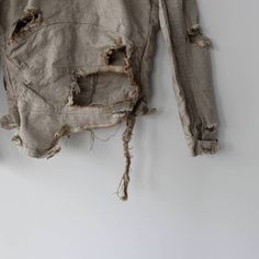 an old jacket that has been torn and is hanging on the wall