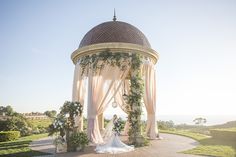 a bride and groom standing under a gazebo at the end of their wedding day