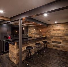 an open concept kitchen with wood paneling and bar stools in the center area