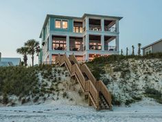 a house on the beach with stairs leading up to it