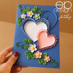 a handmade card with two hearts and flowers on the front, in blue paper