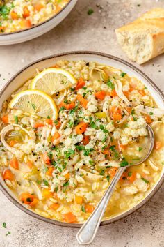 two bowls filled with chicken noodle soup and lemon slices