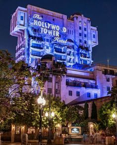 the hollywood tower hotel is lit up in purple and blue for the holidays on display