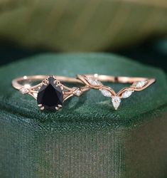 a black diamond ring sitting on top of a green cloth