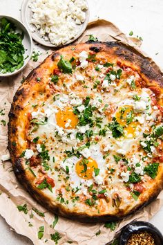 an egg and cheese pizza is cut into four pieces on top of brown parchment paper