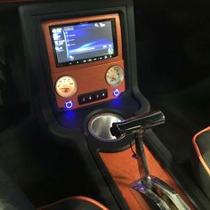 the interior of a car with an electronic device in it's center console and steering wheel