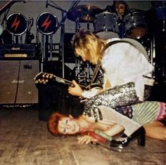 two people are playing guitar on the floor