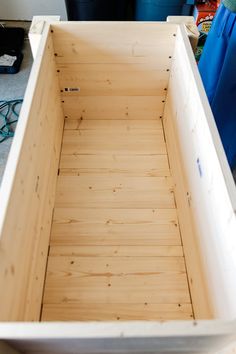 an empty wooden box sitting on the floor