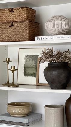 the shelves are filled with vases, books and other decorative items in baskets on them