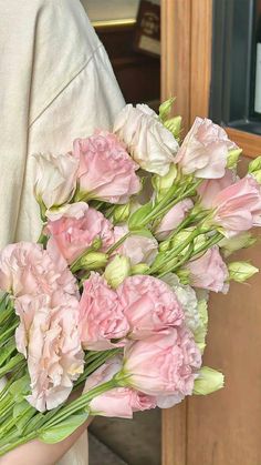 a woman holding a bouquet of pink flowers