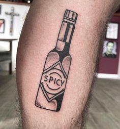 a man with a tattoo on his leg that has a bottle of spicy in it