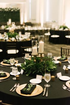 a black table topped with plates and candles