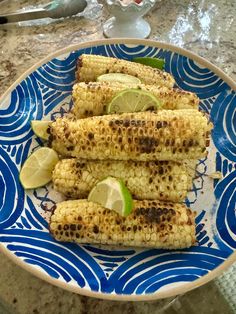 grilled corn on the cob with lime wedges and salt in a bowl