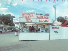 a small food stand with people standing outside