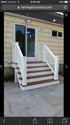 a white porch with steps leading up to the front door