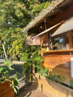 the outside of a restaurant with plants and potted trees