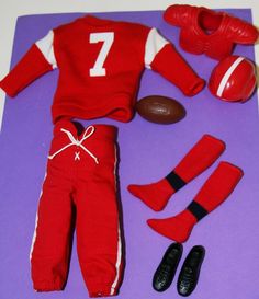 a toy football player's outfit and shoes are laid out on a purple mat