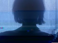 the silhouette of a person in front of a window with blue and green lines on it