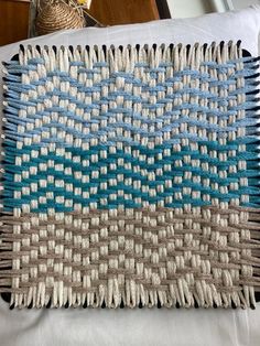 a blue and white rug sitting on top of a bed