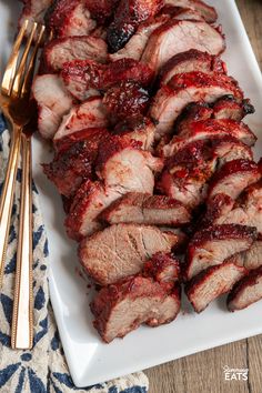 sliced meat on a plate with fork and knife