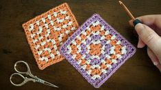 two crocheted squares sitting on top of a table next to a pair of scissors