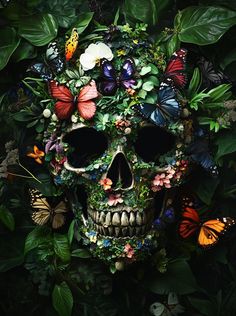 a skull surrounded by flowers and butterflies in the middle of some leaves with one eye open