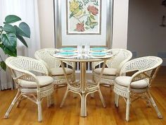 the table and chairs are all white with blue plates on them in front of a window