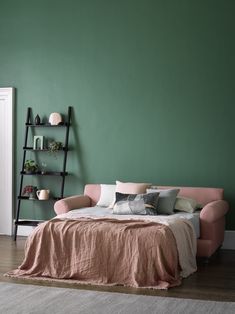 a bedroom with green walls and pink furniture