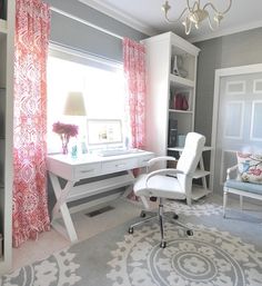 a room with a desk, chair and bookcase in the corner is decorated in pink and gray