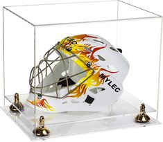 a goalie helmet in a clear case with bells on the side and flames all over it