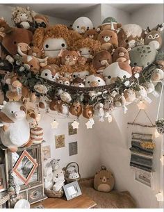 a room filled with lots of stuffed animals hanging from it's ceiling above a table