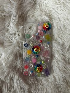 an iphone case filled with lots of different colored buttons on a white furnishce