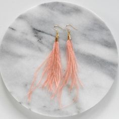 These elegant feather earrings are perfect for a wedding or any night out! The soft peachy blush shade works well as a neutral or as a fun accent. + lightweight blush ostrich feathers+ gold-plated ear wire hooks (lead-free and nickle-free)+ comes with plastic earring back for security+ approximately 5-6 inches long   (each piece is handmade so lengths are approximate)+ packaged on a hand-stamped kraft earring card in a clear resealing bag making them ready for gift givingMORE FEATHER EARRINGSTo Elegant Feather Dangle Earrings, Elegant Dangle Feather Earrings, Elegant Dangle Earrings With Feathers, Feather Earrings For Summer, Elegant Adjustable Feather Earrings, Elegant Pink Fringe Jewelry, Elegant Feather Earrings, Summer Party Earrings With Feathers, Feather Party Jewelry For Summer