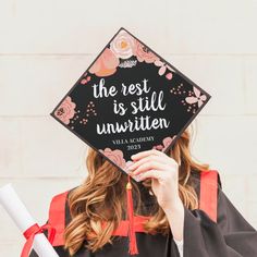 a woman wearing a graduation cap that reads the rest is still unwritten