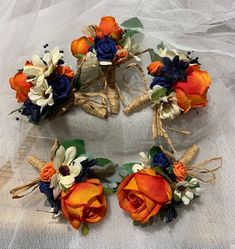 the bridal bouquets have been made with orange and blue flowers