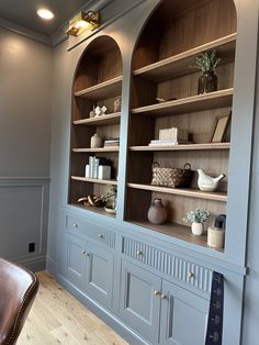 a large bookcase with many shelves and vases on it's sides in a living room