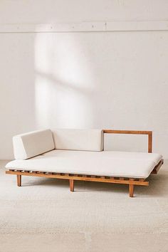 a white couch sitting on top of a wooden frame