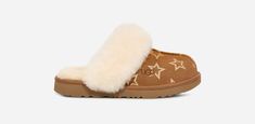 Our snUGG®ly Cozy II gets decorated with iridescent stars for your kids to shine in. This style has all the features of the original: soft suede upper and UGG®plush upcycled wool-blend interior and our upgraded pattern that will have them reaching for the stars. | Suede with foil print upper. Sheepskin collar. 17mm UGG®plush 60% upcycled wool, 40% TENCEL Lyocell lining. 17mm UGG®plush 60% upcycled wool, 40% TENCEL Lyocell insole. Sugarcane EVA outsole. Textile binding made from 100% recycled pol Ugg Sneakers, Trendy Shoes Sneakers, Winter Mittens, Sheepskin Slippers, Kids Slippers, Ugg Slippers, Reaching For The Stars, Slippers Cozy, Woven Labels