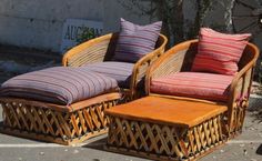 two wicker chairs and a footstool on the sidewalk