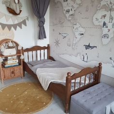 a child's bedroom with a map on the wall and a bed in it