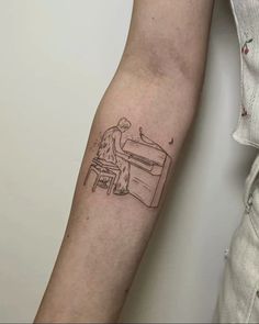 a person sitting at a desk with a computer tattoo on their arm