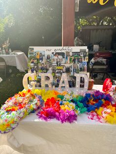 there is a sign that says grad on it and flowers all over the table