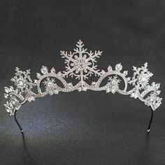 a tiara with snowflakes and crystals on the headband is seen in this image